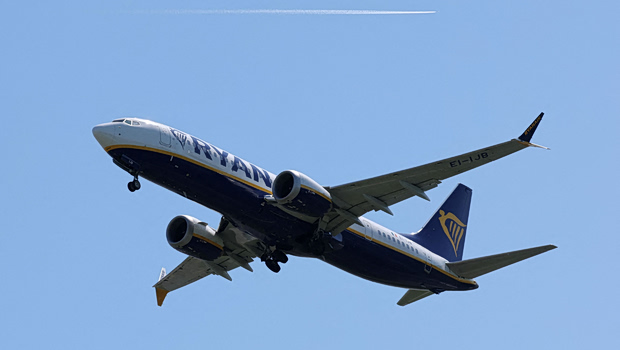 Αεροπλάνο σε διάδρομο αεροδρομίου με δεξαμενές καυσίμων