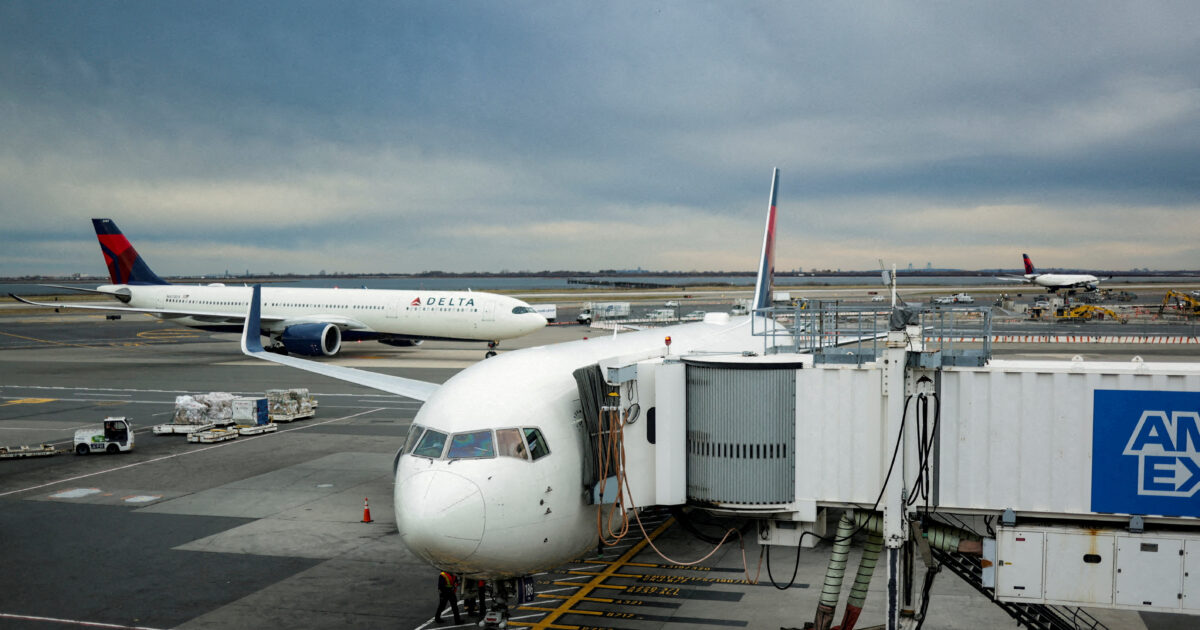 Αεροπλάνο σε διάδρομο αεροδρομίου με δεξαμενές καυσίμων